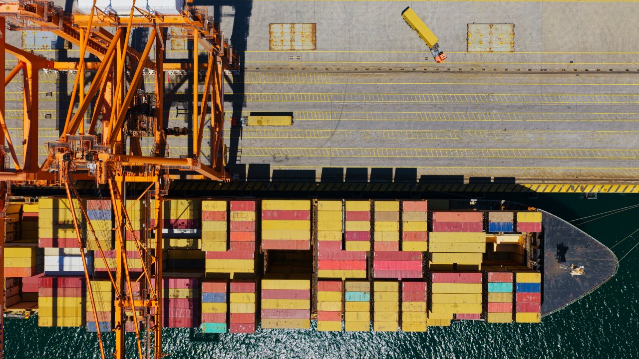 Port container crane working a vessel at the terminal.