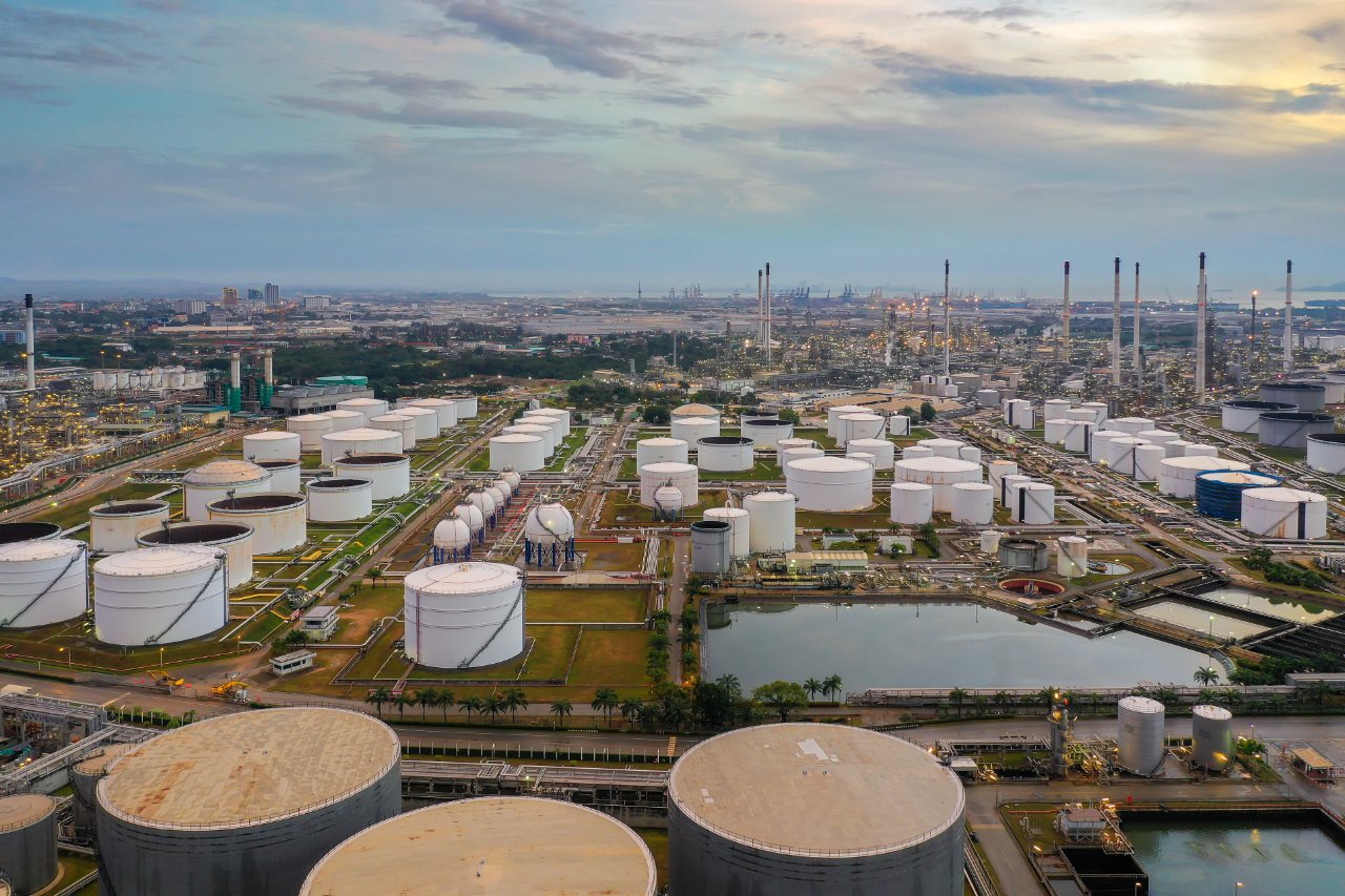 Aerial view of storage tanks at a waterfront energy terminal at dusk